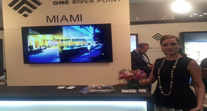 Stand de One River Point y la Directora de Ventas del proyecto, Adriana Vargas.